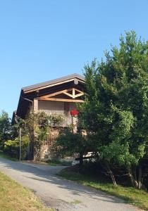 a house on the side of a road with a tree at Le Notti Magiche in Occhieppo Superiore