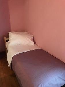 a small bed with white sheets and pillows in a room at Le Notti Magiche in Occhieppo Superiore
