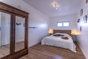 una camera da letto con un letto e un grande specchio di Privatisation des gîtes du Domaine Font Castel a Béziers