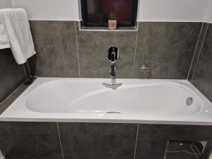 a white bath tub with a faucet in a bathroom at Tranquil Haven Suites in Gaborone