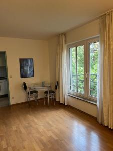 un salon avec une table et des chaises et une fenêtre dans l'établissement Ruhiges Apartment in Dresdner Neustadt, à Dresde