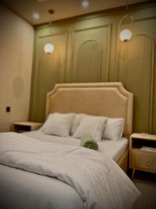 a bedroom with a bed with white sheets and pillows at 1-BHK Velvet Keys Executive Suite Near Clifton Beach in Karachi +10 photos