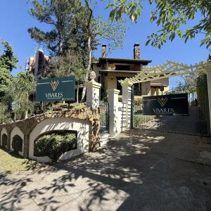 a gate to a house with a bridge at Vivares Pousada Boutique Gramado in Gramado