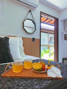 a tray of orange juice and fruit on a table at Pousada Recanto da Família in Natal