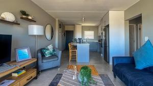 a living room with a couch and a table at Nivica Lifestyle Apartment in Langebaan