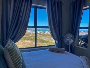 a bedroom with a bed and a large window at Nivica Lifestyle Apartment in Langebaan