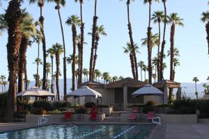a resort with palm trees and a swimming pool at TWO Guest Suites ON Tee Box #2 Palm Valley Country Club with access to Tennis and Athletic Club Two on #2! in Palm Desert