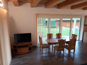 a dining room with a table and chairs and a television at Chata u Repáňov in Terchová