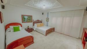 a bedroom with two beds and a couch in it at Casa Vallenata boutique in Valledupar