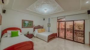 a bedroom with two beds and a window at Casa Vallenata boutique in Valledupar