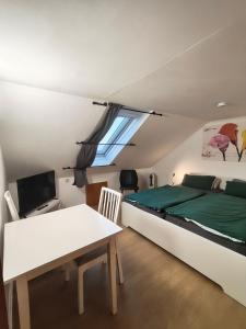 una camera da letto con un letto, un tavolo e una finestra di Deisterferien FeWo Hygge unterm Dach, 3 Personen, Balkon, Nur Netflix, WLAN, A2 Nähe a Beckedorf