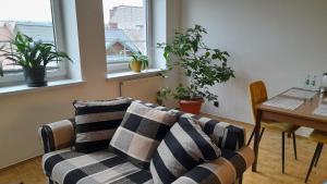 a living room with a couch and a table and windows at Apartament Centrum in Nowy Targ +4 photos