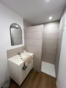 a white bathroom with a sink and a mirror at Charmant T1 bis in Mérignac