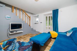 a living room with a blue couch and a tv at Apartment Pavilion in Kampor