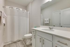 a white bathroom with a toilet and a sink at 3 Mi to Sand! Ocean Isle Beach Escape Near Golf in Seaside +17 photos