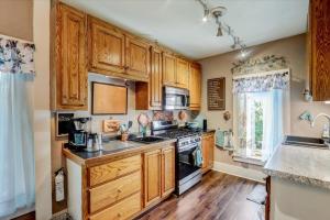 a kitchen with wooden cabinets and a stove at Relax & Reboot 