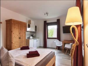 a bedroom with a bed and a desk and a table at Haus Freigeist - zum Gartenblick in Neinstedt