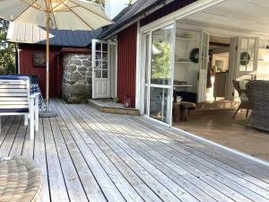 a porch of a house with a wooden deck at 7 person holiday home in HALLABRO in Hallabro +65 photos