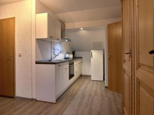 a kitchen with white cabinets and a white refrigerator at Haus Freigeist - zum Ortsblick in Neinstedt +9 photos