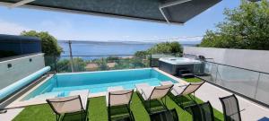 a patio with a swimming pool and chairs on a balcony at Villa Eva in Dramalj