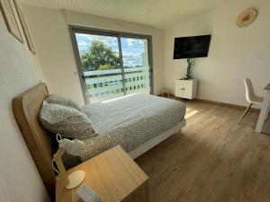 Un dormitorio pequeño con una cama y una ventana. en Studio lumineux de 23m avec balcon, en Bagnoles de l'Orne