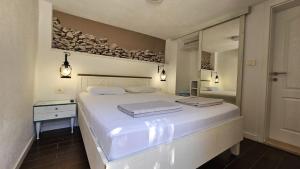 a bedroom with a large white bed and a mirror at Villa Brač in Sumartin +38 photos