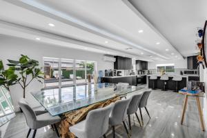 Un salón con un mostrador de cristal y sillas. en Miami Resort Villa - Volleyball - Jacuzzi - Sauna, en Ives Estates
