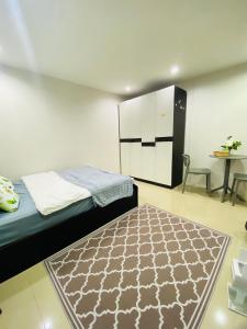 a bedroom with a bed and a rug on the floor at Bulanhome in Sathani Hat Yai