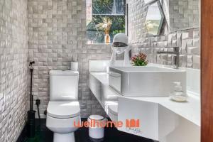 Un baño con un inodoro blanco y un lavabo. en Suite em Tibau do Sul proxima a Praia de Pipa, en Pipa