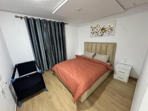 une chambre avec un lit et une chaise dedans dans l'établissement CORALIA Bel F3 N35, à Oujda
