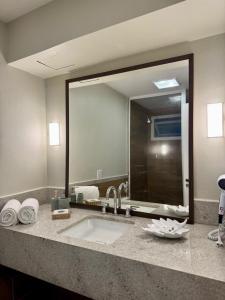 un bagno con un lavandino e un grande specchio di Buzios Beach Resort a Búzios