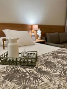 un letto con un vassoio e un vaso sopra. di Buzios Beach Resort a Búzios Altre 30 foto