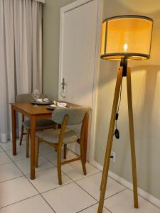 un tavolo e una lampada accanto a un tavolo e una sedia di Buzios Beach Resort a Búzios