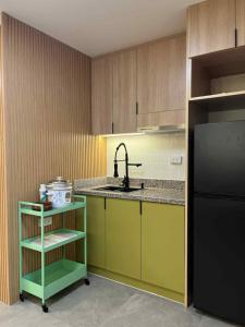 cocina con fregadero y nevera negra en Kage-no-Wa Suite Netflix, Disney, HBO 2BR, en Manila