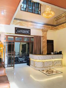 een lobby van een hotel met een kroonluchter bij Among Rogo Syariah in Yogyakarta