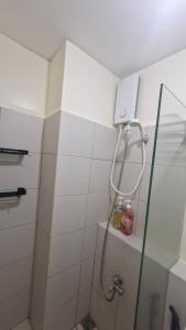 Un baño con ducha con puerta de cristal. en Kage-no-Wa Suite Netflix, Disney, HBO 2BR, en Manila