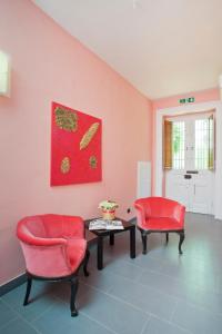 
a living room filled with furniture and a red wall at Palazzo Lombardo in Florence
