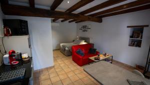 a living room with a red couch and a table at Le Petit Mona Althéa in Civaux