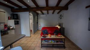 Una sala de estar con un sofá rojo y una mesa. en Le Petit Mona Althéa, en Civaux