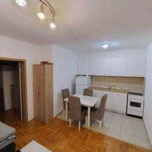 a kitchen with a table and chairs in a room at Knez in Požarevac