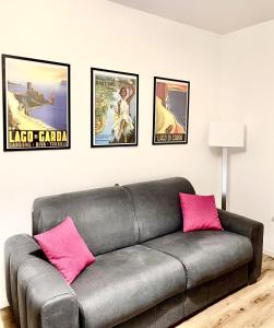 a living room with a gray couch with pink pillows at Da Sandro Holidays Apartment in Arco