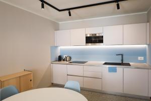 a kitchen with white cabinets and a table and chairs at Palazzo Righi in Carisolo