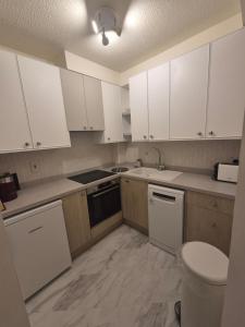 a kitchen with white cabinets and a sink at New Unique room beside Tramline in Citywest