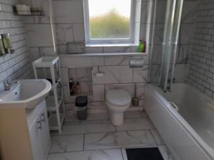 a bathroom with a toilet and a sink and a tub at New Unique room beside Tramline in Citywest