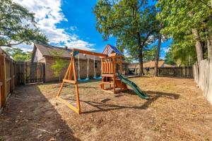 a playground in a yard with a swing at Spacious Humble Retreat - Near IAH & Lake Houston - Sleeps 9 in Humble