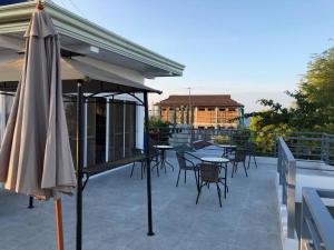 a patio with tables and chairs and an umbrella at Casita Angela in Panglao