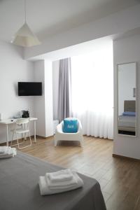 a room with a bed and a chair and a mirror at BlueB&B in Pagani