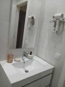 a white bathroom with a sink and a mirror at Casa do Hilário in Viseu +4 photos