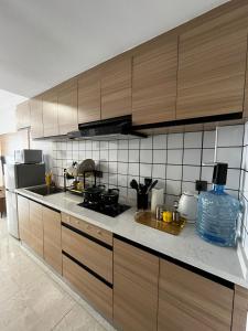a kitchen with wooden cabinets and a bottle of water at Little Loft - The Loftel Ruaka in Nairobi