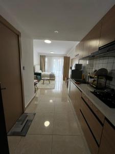 a kitchen with a counter and a living room at Little Loft - The Loftel Ruaka in Nairobi